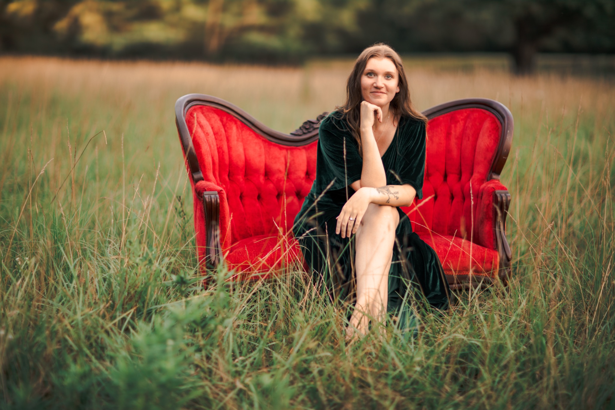 Alyssa Estelle seated on a red sofa outdoors